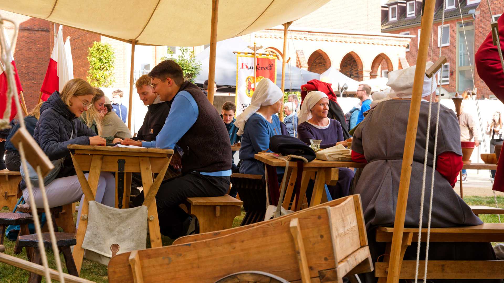Menschen sitzen und spielen beim Hansevolk auf dem Hansekulturfestival
