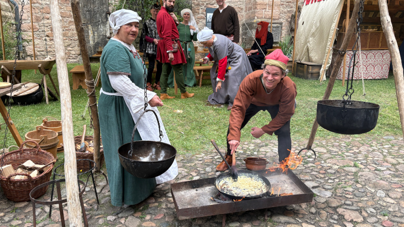 Hansevolk beim mittelalterlichen Kochen auf offenem Feuer